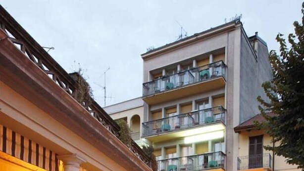 An outdoor dining area of Bar Elena with tables and chairs, surrounded by potted plants. - Hotel Elena (Stresa)
