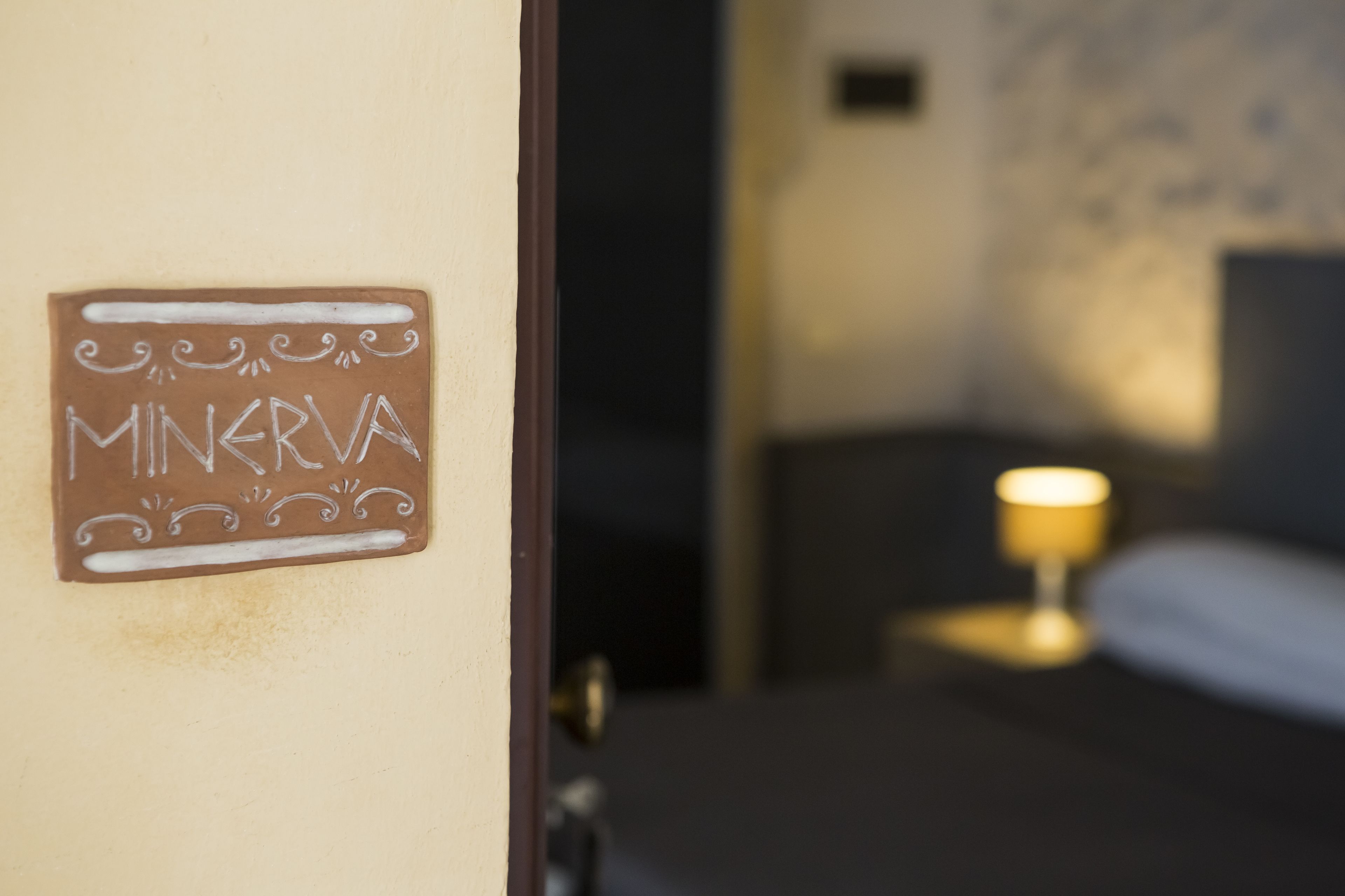 A sign on a wall that reads "MINERVA" with a decorative border.