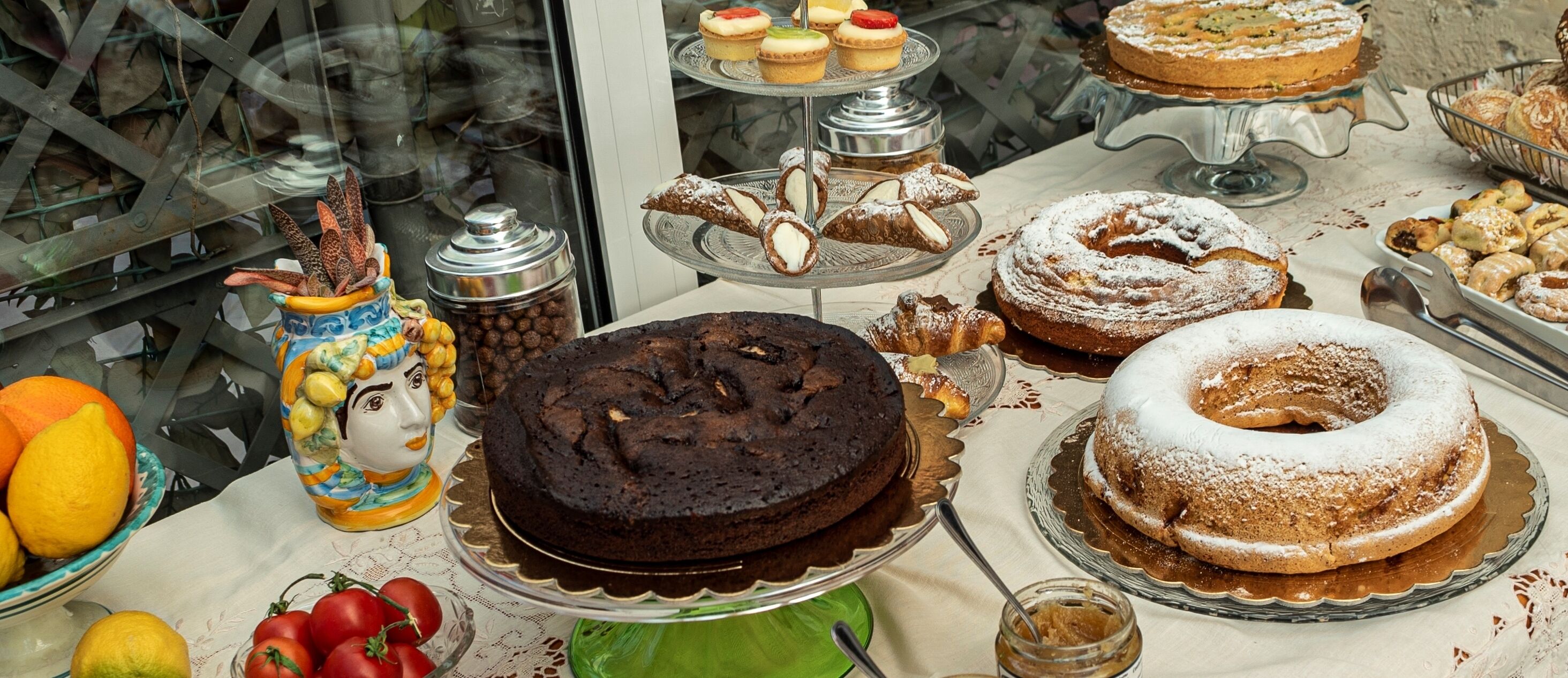 Une variété de desserts étaient exposés, notamment des gâteaux et des pâtisseries, présentés sur plusieurs présentoirs en verre.