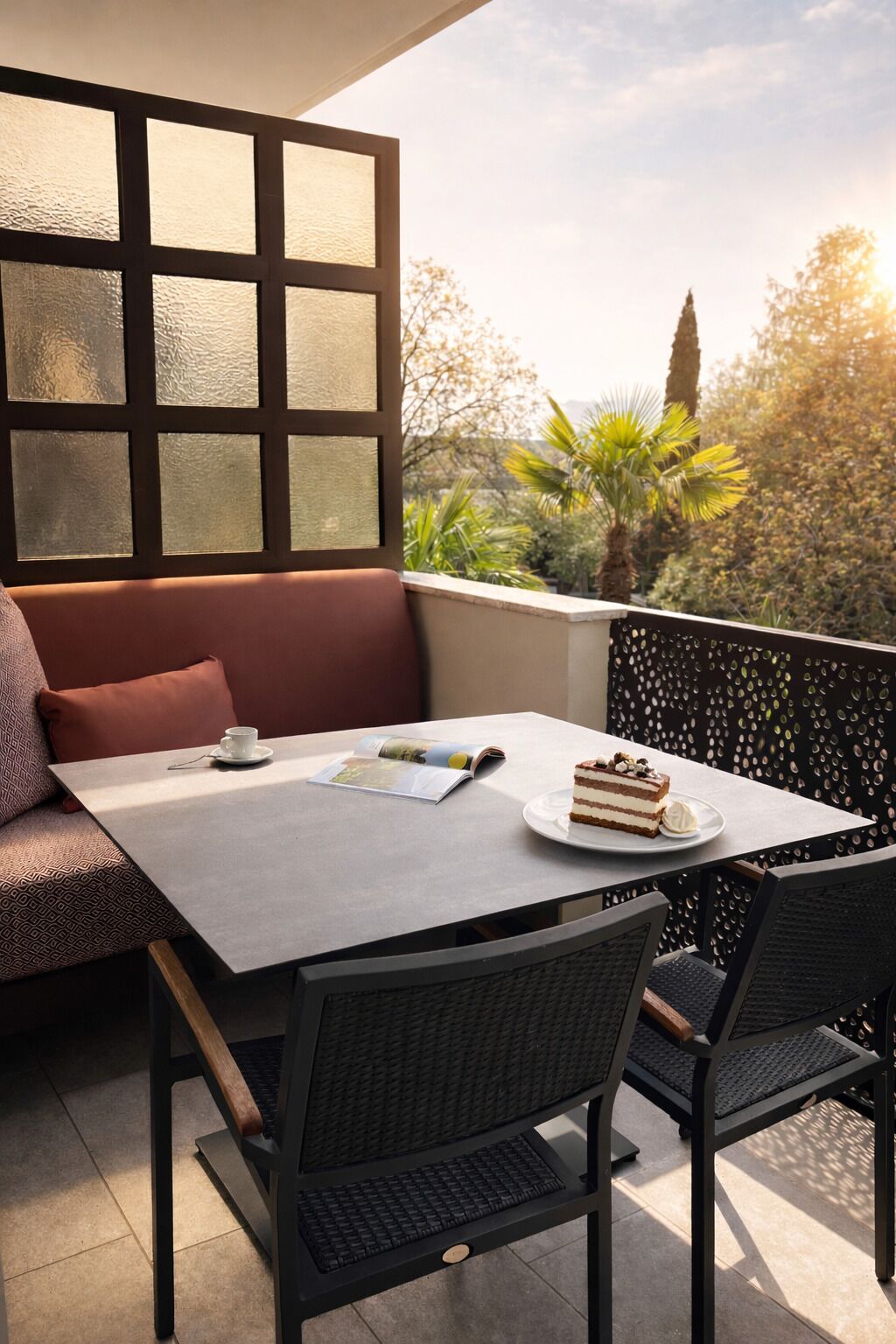 Un balcone con un tavolo, sedie, un divano e una finestra con vetri satinati.