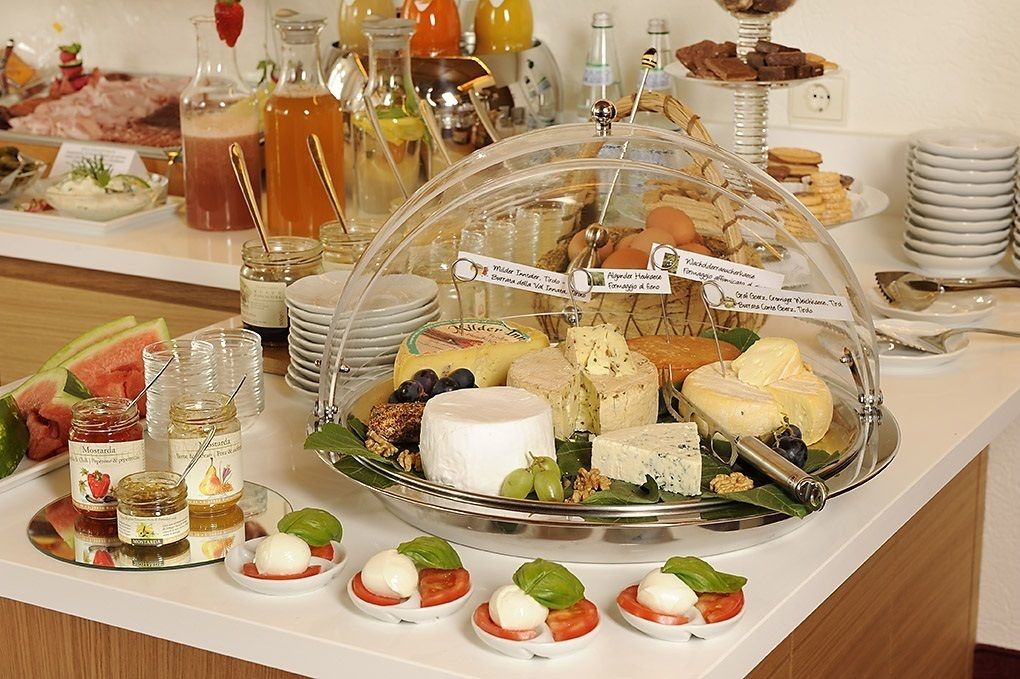 Un buffet proposant une variété de fromages, de fruits et de condiments.