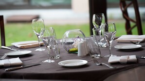 A table set for a meal with clear glassware, plates, and cutlery. - Hôtel Les Vallées (La Bresse)