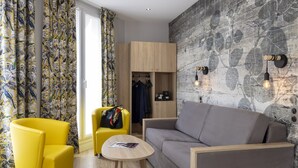 Una habitación moderna con sofá, dos sillones amarillos, una mesita y un armario.