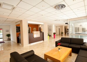 A modern lobby with a reception desk, seating area, and a chandelier. - Hotel Milton (ex Gis Hotel) (Neuilly-Plaisance)