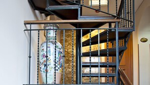 A multi-level interior with a staircase, a decorative vase, a mirror, and a small Christmas tree. - Arco di Travertino (Rome)