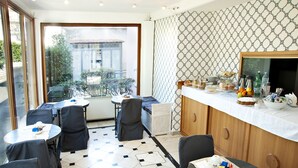 A dining area with tables and chairs, a buffet with food and drinks, and a view of the outside. - Arco di Travertino (Rome)