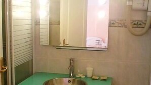 Ein Badezimmer mit einem grünen Waschbecken, einem Spiegel und einem Handtuchhalter.