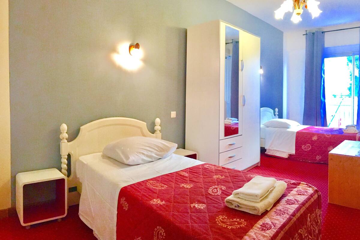 Une chambre d’hôtel comprenant un lit, une armoire, une table de chevet et un miroir.