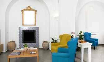Una sala de estar moderna con chimenea, dos sillones, una mesa de centro y jarrones decorativos.