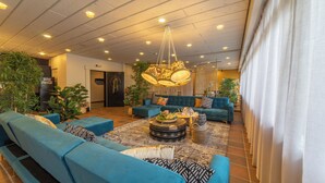 A spacious living area with multiple sofas, a coffee table, and a hanging light fixture.