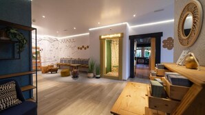 A modern interior with a wooden floor, a blue sofa, a wooden table, and a decorative mirror.
