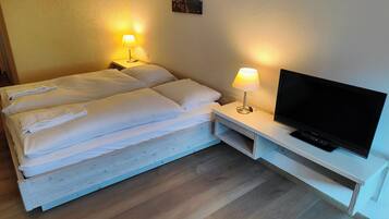 Una habitación de hotel con una cama, dos lámparas de noche, un televisor y un cuadro en la pared.