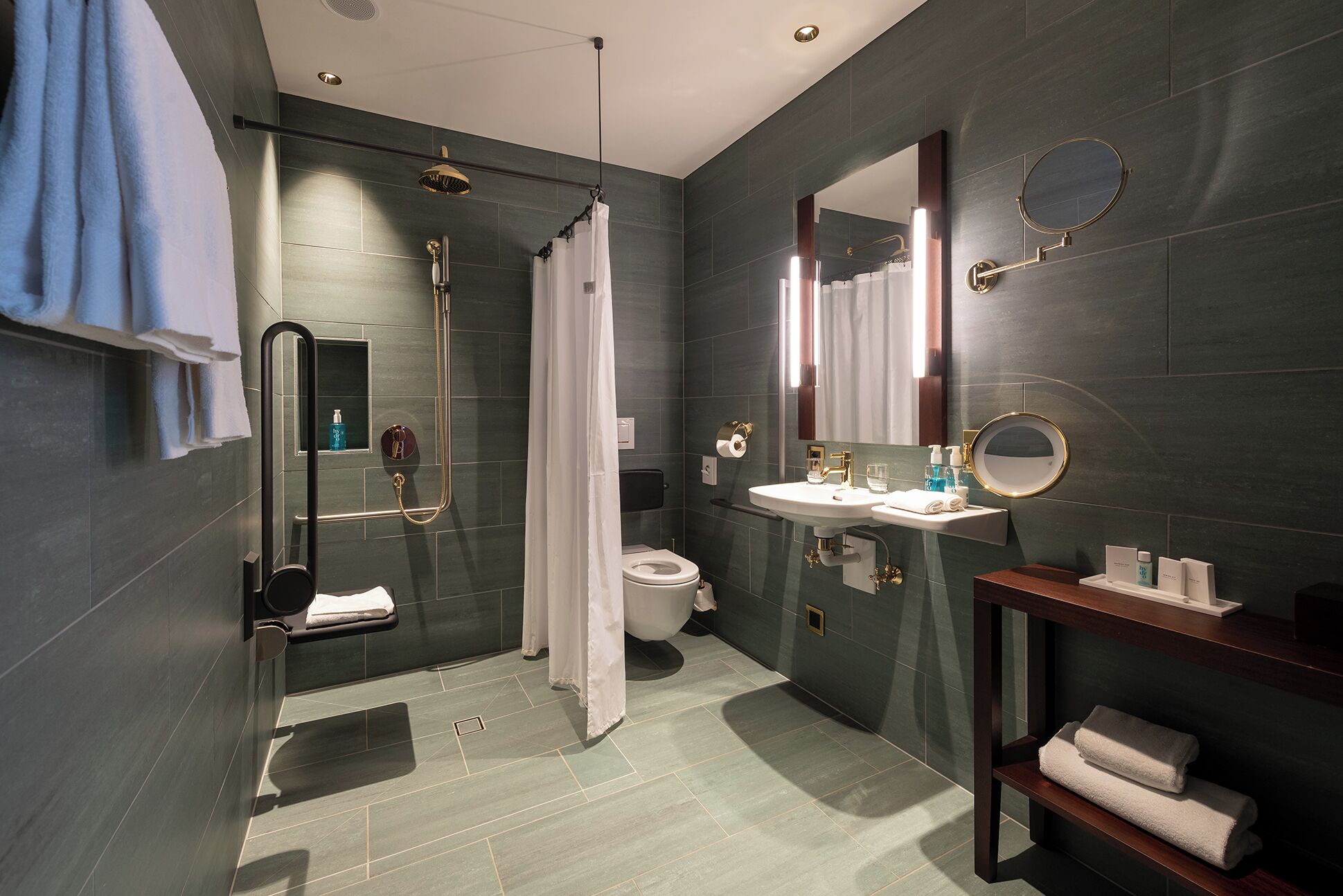 A modern bathroom with a shower, toilet, sink, and a mirror.