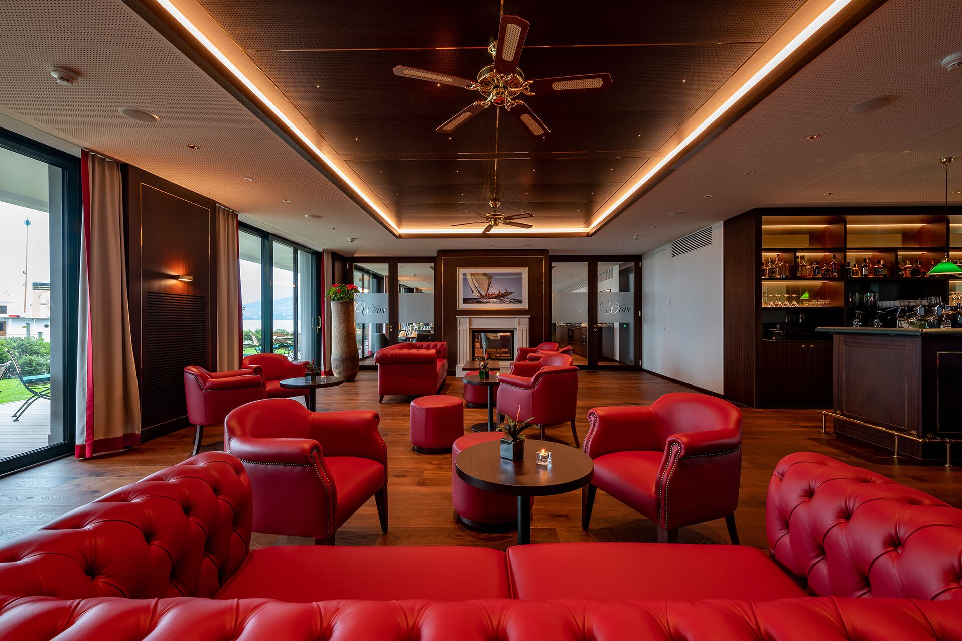 A modern lounge area with red leather sofas and a bar.