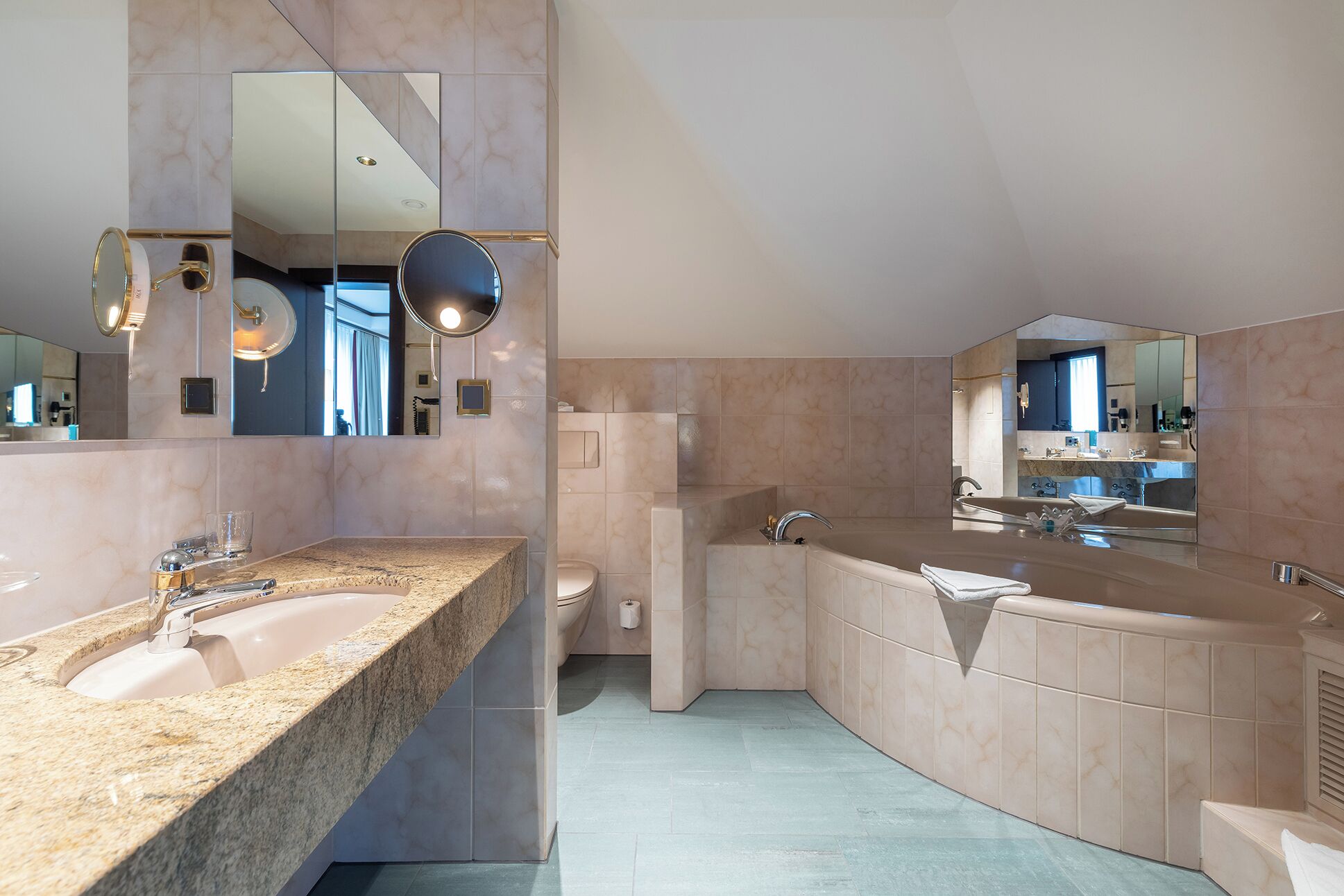 A modern bathroom with a large vanity, a bathtub, and a shower area.