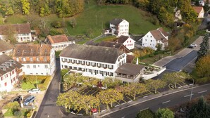 An aerial view of a hotel with a central courtyard, surrounded by residential buildings and a road. - Bad Eptingen (Eptingen)
