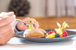 Un plato de postre con helado y diversas bayas.