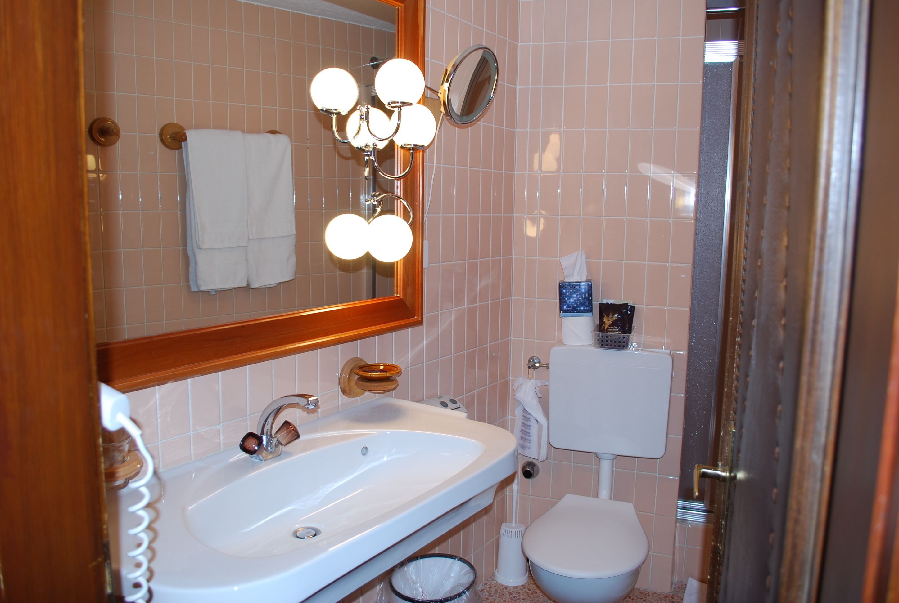 A bathroom with a sink, mirror, and toilet.