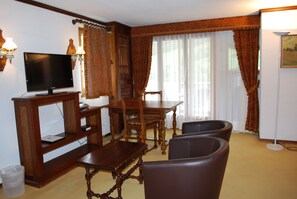 Habitación triple, planta baja | Área de sala de estar | Televisión de plasma 