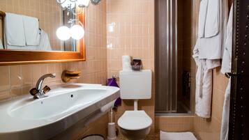 A bathroom with a sink, toilet, and shower.