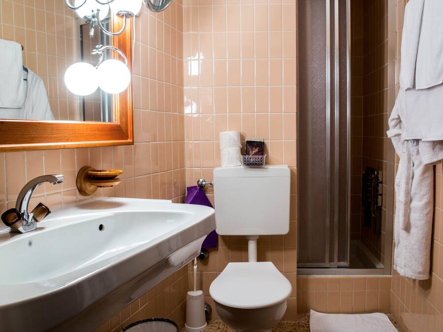 A bathroom with a sink, toilet, and shower.