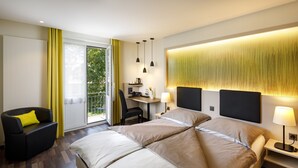 A modern hotel room with a large bed, a desk, and a chair. - Hotel Jardin (Bern)
