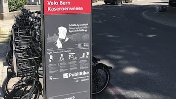 A public bike rental station with a sign for Velo Bern Kasernenwiese, including a map and instructions.