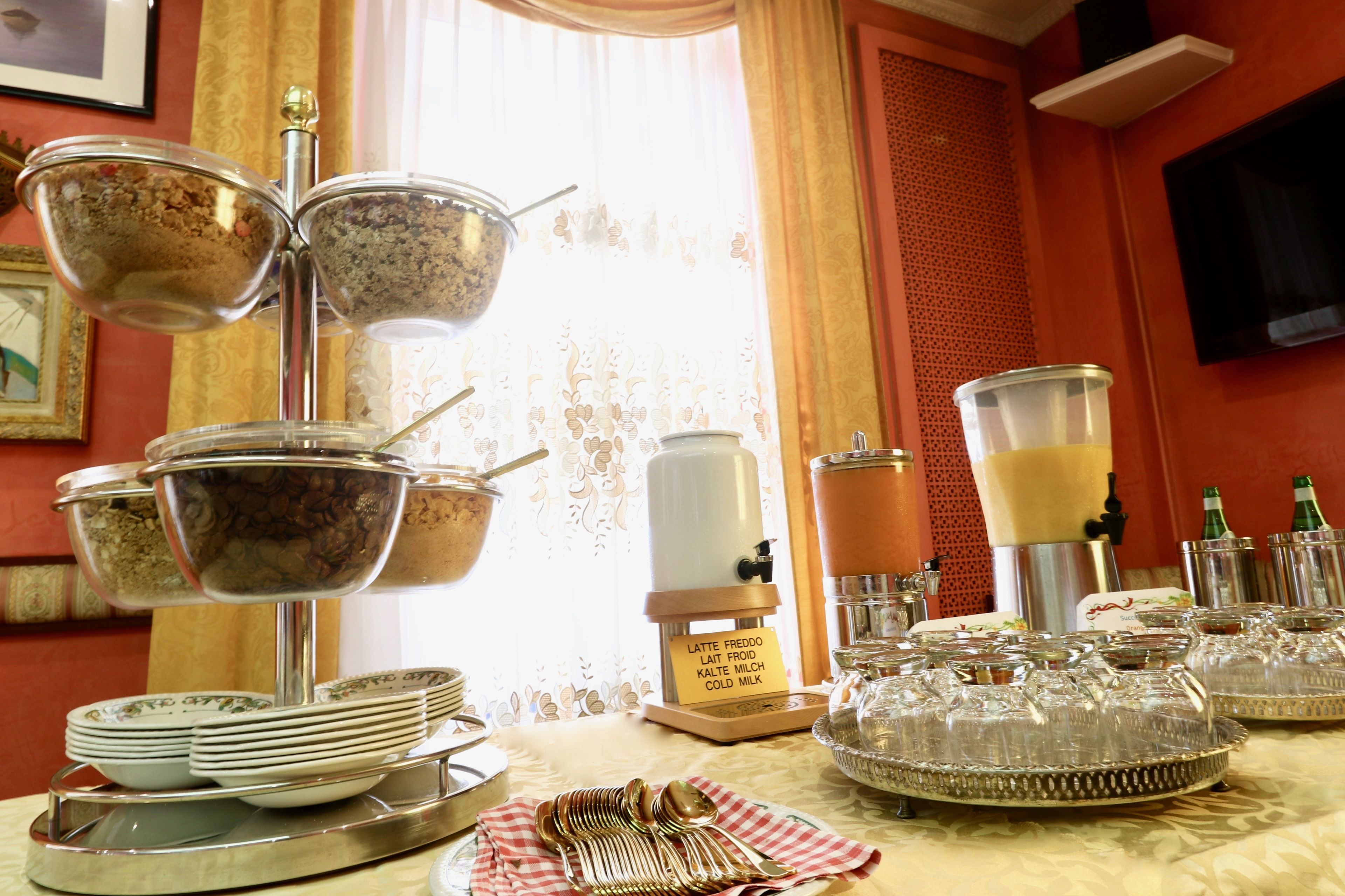Montaje de bufé con varias estaciones de servicio, incluyendo tazones de comida y un dispensador de café.