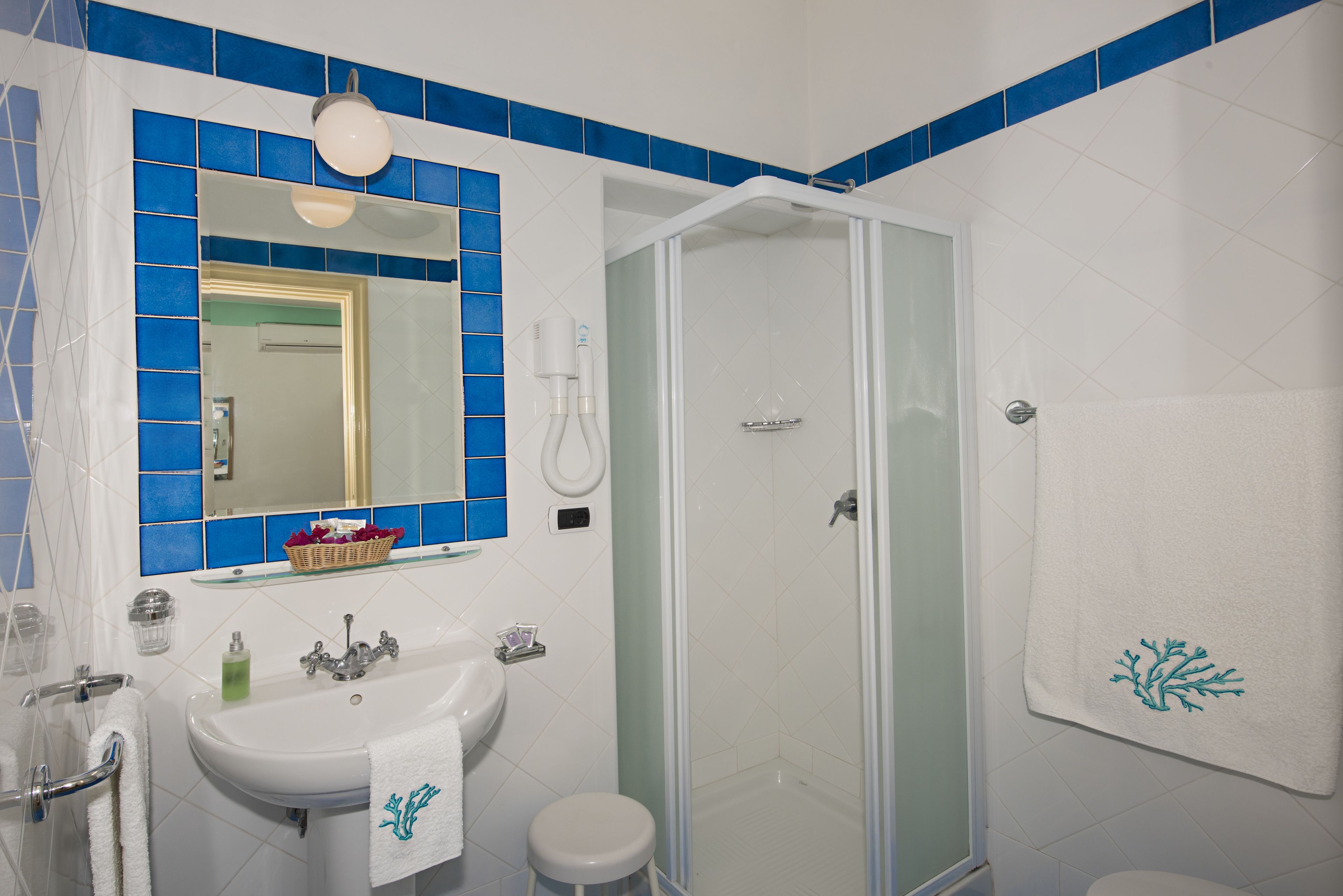 A bathroom with a sink, mirror, and shower.