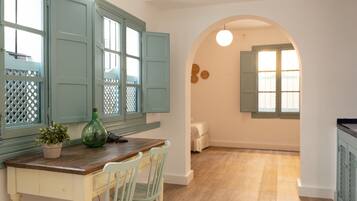 A kitchen with a wooden table, two chairs, a potted plant, and teal cabinets.