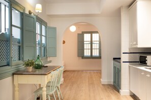 A kitchen with a wooden table, chairs, and cabinets. - Apartamentos Suites Santa Cruz (Seville)