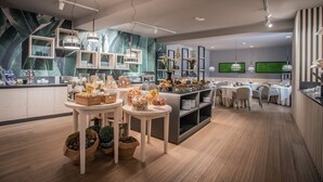 Un restaurante moderno con suelo de madera, mesas blancas y diversos alimentos expuestos en mesas y estanterías.