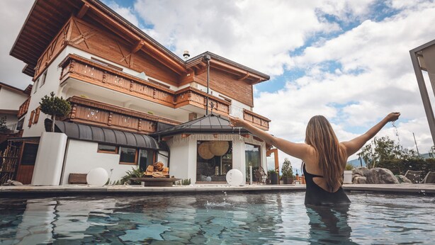 Un edificio moderno de dos pisos con una piscina al frente.