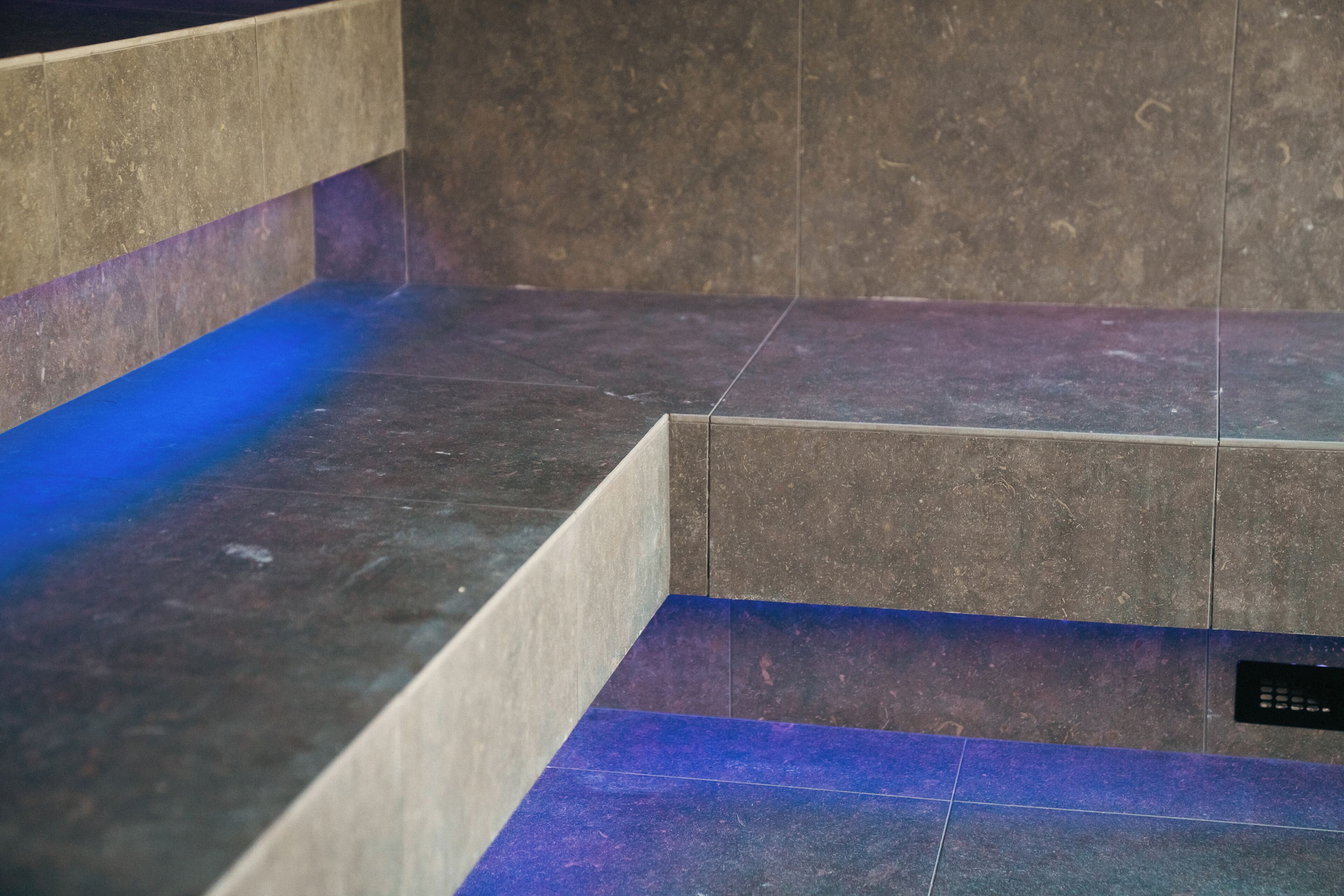 Un pavimento piastrellato con una striscia luminosa blu.