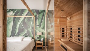 Una habitación de hotel moderna con una cama, una mesita de noche, una pequeña zona de sauna de madera.