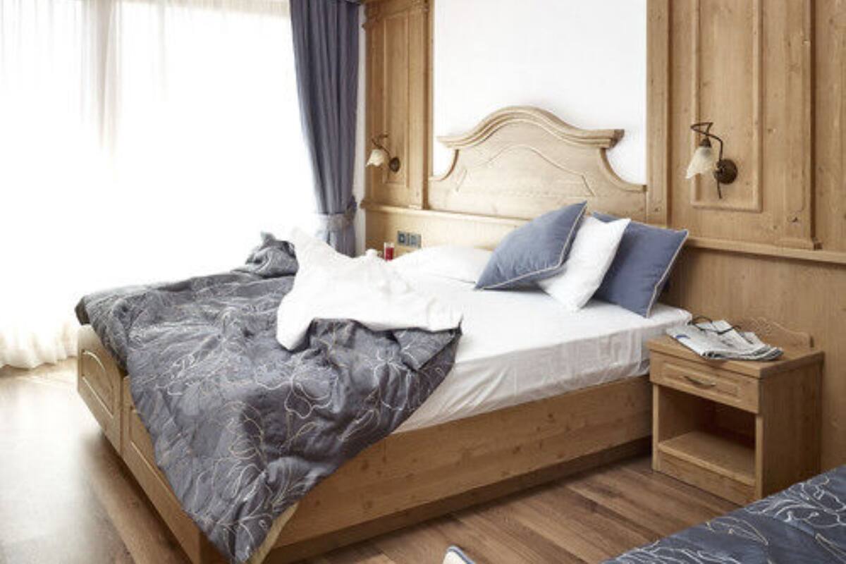 A bedroom with a wooden bed, a nightstand, and a wardrobe.