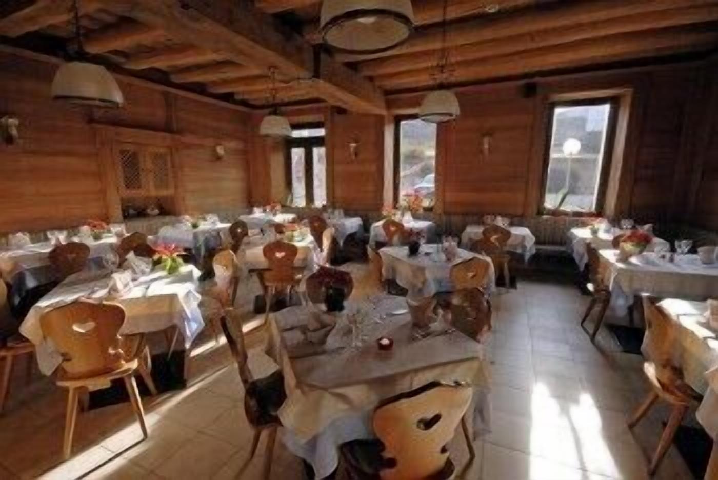 A dining area with wooden walls and tables set for multiple guests.