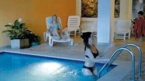 An indoor swimming pool with lounge chairs and a tiled floor. - Stella delle Alpi (Ronzone)