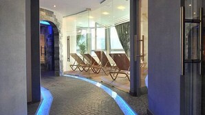 Ein modernes Interieur mit einem blauen, geschwungenen Weg, einer Sitzgelegenheit mit Stühlen und Glaswänden.