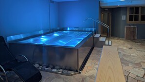 A modern spa area with a heated floor, a seating area, and a stone-tiled floor. - Hotel Arnica (Pinzolo)