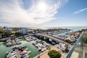 Una marina con numerose imbarcazioni ormeggiate, un ponte che scavalca l'acqua e edifici sullo sfondo.