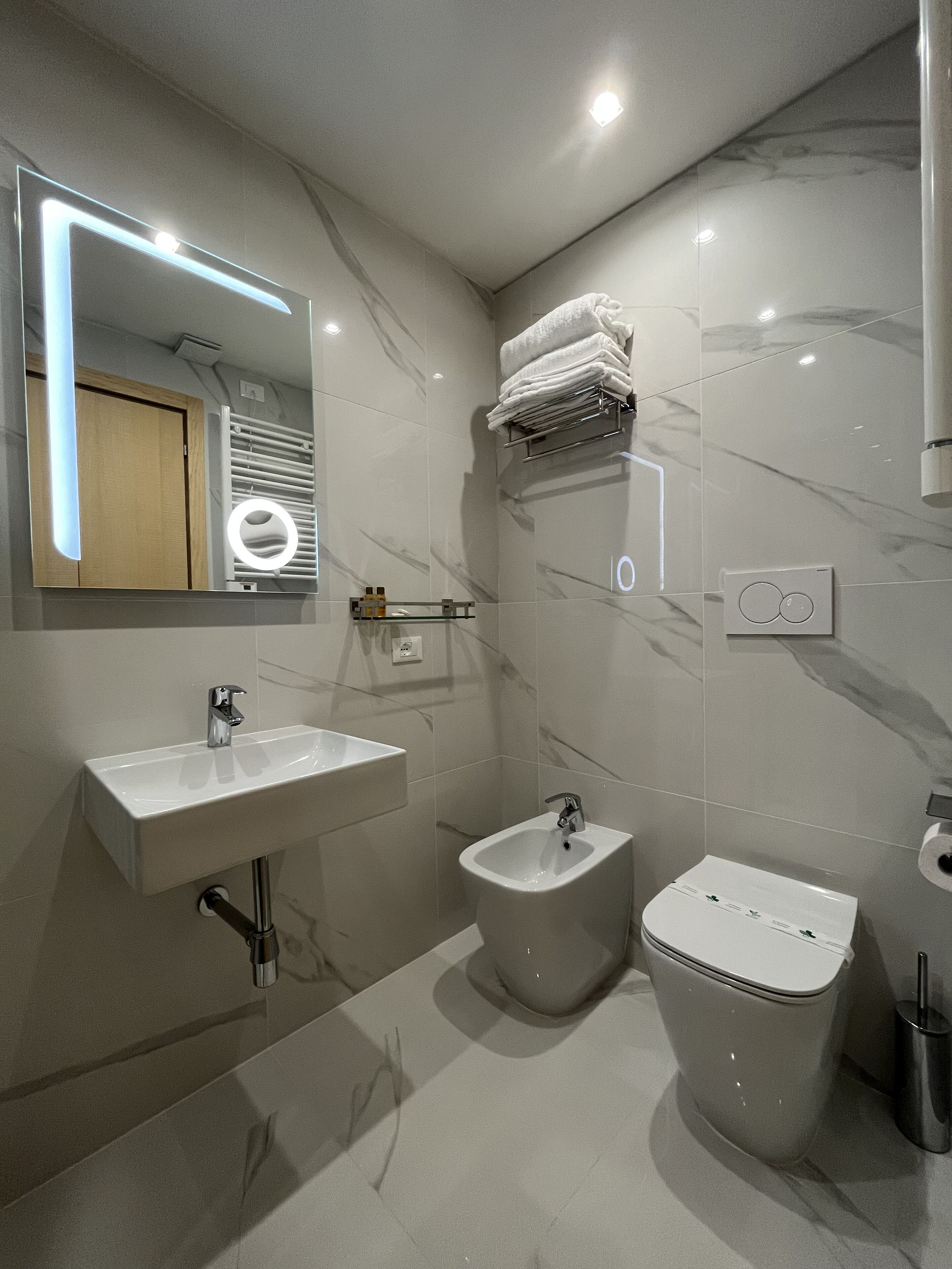 Een moderne badkamer met een wastafel, bidet en toilet.