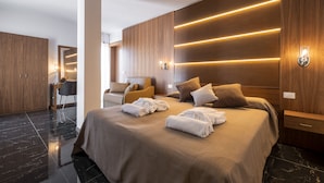 Una habitación de hotel moderna con una cama grande, paneles de madera e iluminación empotrada.