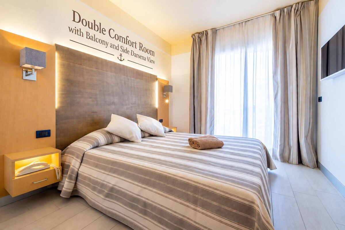 A double comfort room with a balcony and side Darsena view.