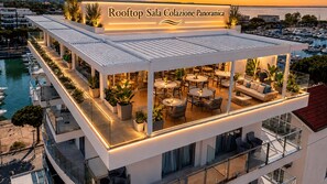 A rooftop bar with outdoor seating and a view of the marina. - Hotel Mare (Lignano Sabbiadoro)