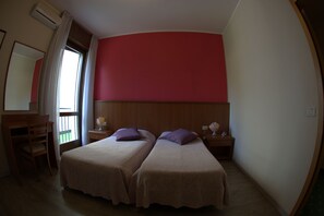 A room with two beds, a desk, and a chair. - Hotel Bristol (Riva del Garda)