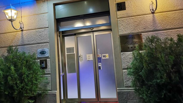 A hotel entrance with a glass door, a red carpet, and a sign indicating it is a hotel. - Hotel Orchidea (Turin)