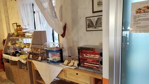 A breakfast buffet with various food items and a coffee machine. - Hotel Orchidea (Turin)