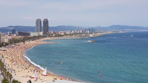 Un paisaje urbano costero con una playa extensa, aguas azules cristalinas y edificios modernos.