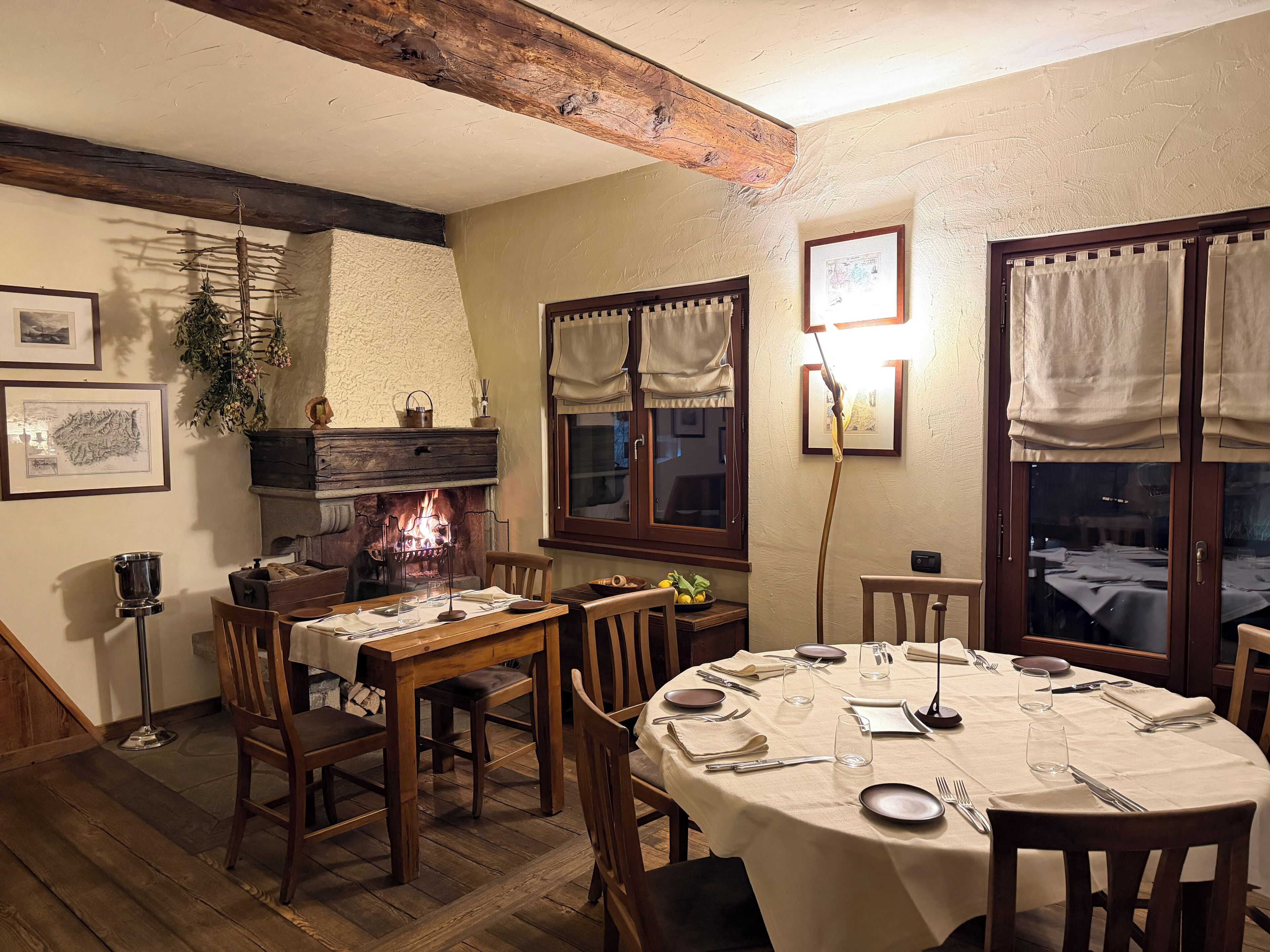 Un'accogliente sala da pranzo con camino, mobili in legno e un tavolo apparecchiato per un pasto.